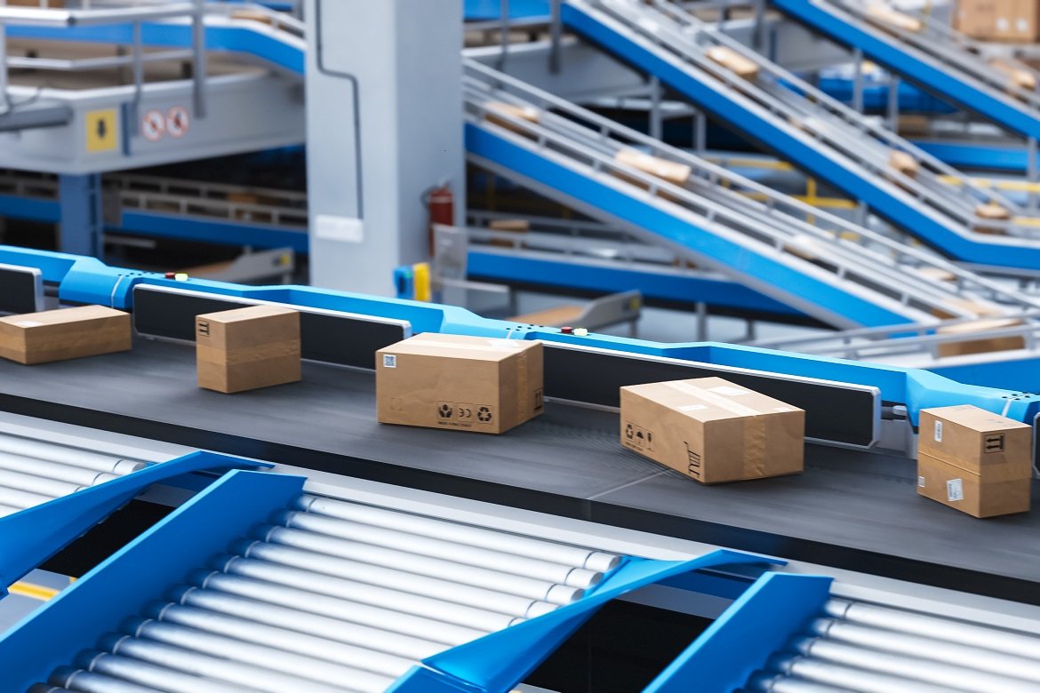 Recyclable cardboard box being transported on a conveyor belt in a modern logistics center. parcel is prepared for delivery to an online client. rendered conveyor system of a big retail business